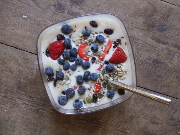 Bol de porridge de flocons d'avoine garni de myrtilles, fraises et graines