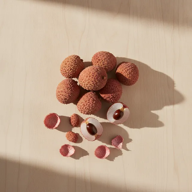 Litchis frais entiers a coque rose et litchis peles a chair blanche translucide, vue de dessus sur une table en bois