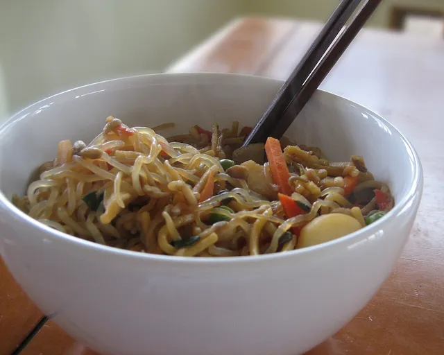 Bol de nouilles shirataki de konjac poêlées avec des légumes et des baguettes