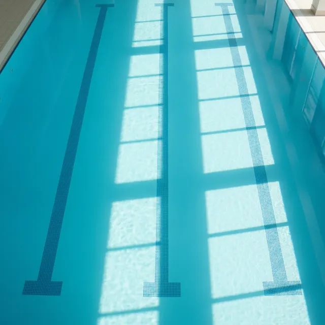 Vue de dessus d'une piscine interieure aux lignes d'eau bleues sous une lumiere naturelle douce