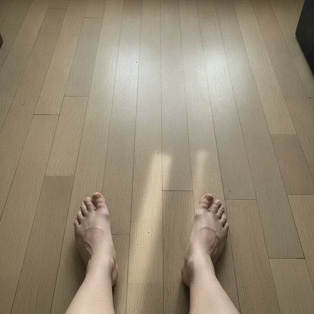 Pieds nus d'adulte marchant sur un parquet clair, vue de dessus