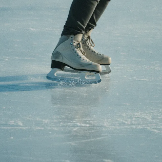 Gros plan sur des patins à glace qui glissent sur une patinoire
